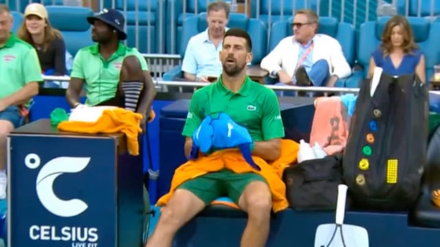 Novak Djokovic zieht sich beim Seitenwechsel ungewöhnliche Handschuhe über