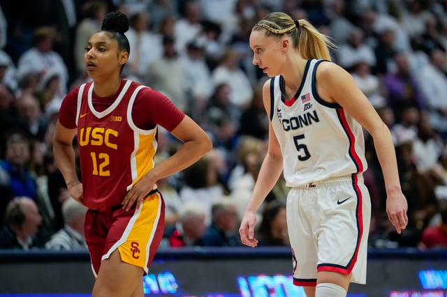 JuJu Watkins #12 of the USC Trojans and Paige Bueckers #5 of the Connecticut Huskies play against each other during the first half of an NCAA women&#39;s basketball game at the XL Center on December 21, 2024 in Hartford, Connecticut. The UConn star guard sends her best wishes to the USC star guard, who suffered a torn ACL.