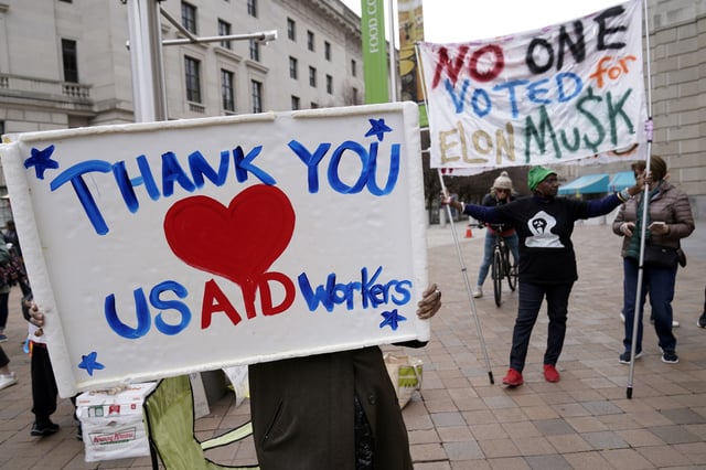 FILE - Supporters cheers the United States Agency for International Development (USAID) workers, as they carry their personal belongings after retrieving them from the USAID's headquarters in Washington, Thursday, Feb. 27, 2025. (AP Photo/Jose Luis Magana, File)