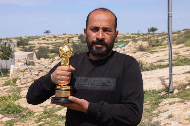 Palestinian filmmaker Hamdan Ballal poses for a picture with his Oscar, won for "No Other Land," as he recovers after Israeli settlers attacked him at home in his village of Susya in the south of the occupied West Bank on Mar. 26.