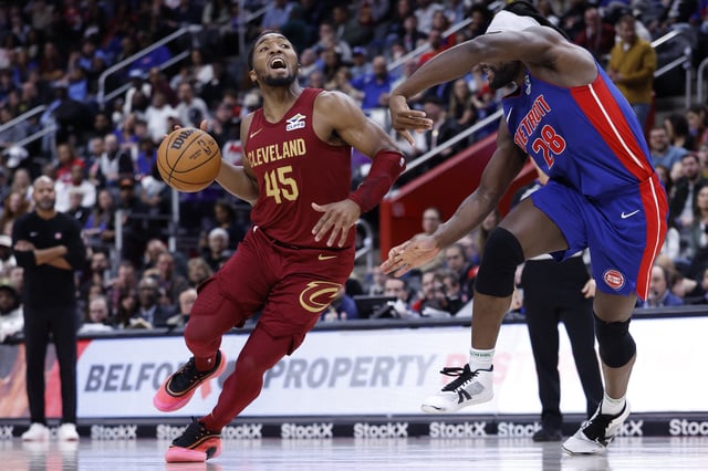 Mar 28, 2025; Detroit, Michigan, USA;  Cleveland Cavaliers guard Donovan Mitchell (45) dribbles defended by Detroit Pistons center Isaiah Stewart (28) in the second half at Little Caesars Arena. Mandatory Credit: Rick Osentoski-Imagn Images