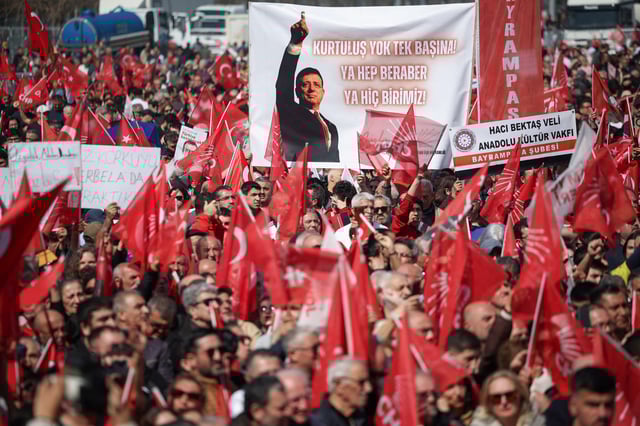 People hold up a poster reading, "There is no liberation alone. Either all together, or none of us", at a rally, to protest against the arrest of Istanbul Mayor Ekrem Imamoglu as part of a corruption investigation, in Istanbul, Turkey, March 29, 2025. REUTERS/Louisa Gouliamaki