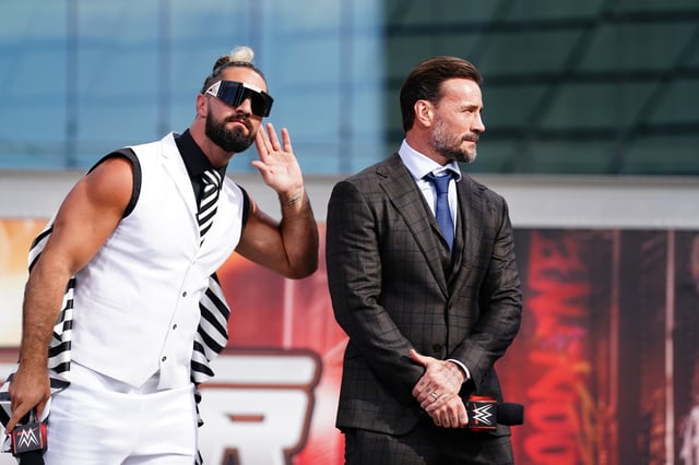 CLEVELAND, OHIO - AUGUST 2: Seth Rollins and CM Punk listen to the crowd during the WWE SummerSlam Kickoff at Rocket Mortgage FieldHouse on August 2, 2024 in Cleveland, Ohio.