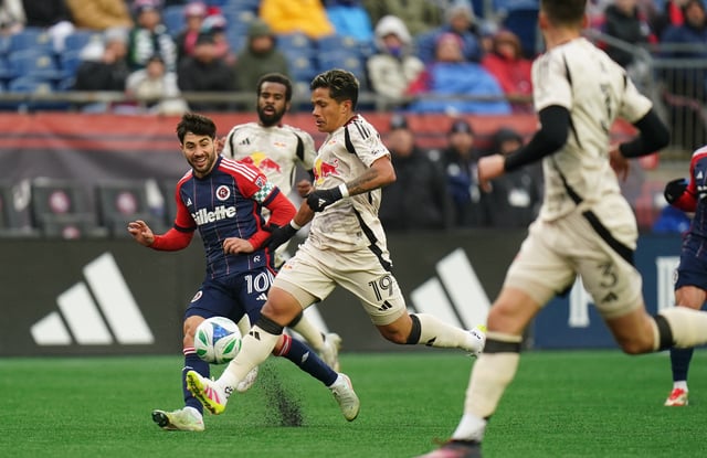 Mar 29, 2025; Foxborough, Massachusetts, USA; New England Revolution midfielder Carles Gil (10) passes the ball against New York Red Bulls midfielder Wikelman Carmona (19) in the first half at Gillette Stadium. David Butler II-Imagn Images