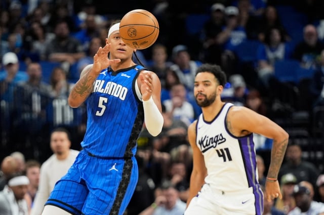 Orlando Magic forward Paolo Banchero (5) collects a pass in front of Sacramento Kings forward Trey Lyles (41) during the first half of an NBA basketball game, Saturday, March 29, 2025, in Orlando, Fla. (AP Photo/John Raoux)