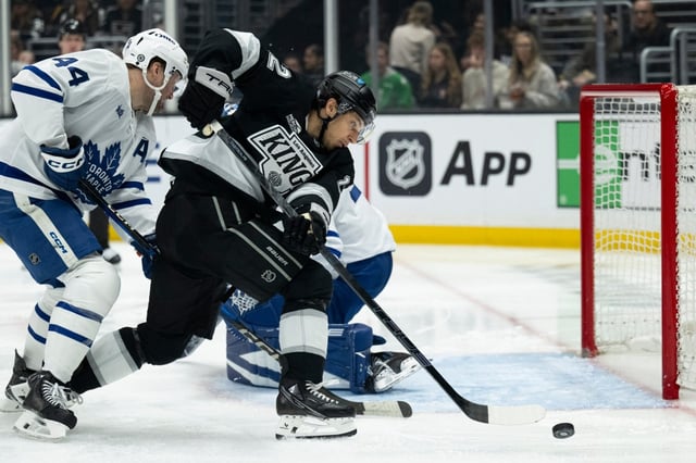 Kings left wing Trevor Moore (12) reaches for the puck in front of the goal during the second period of an NHL hockey game against the Toronto Maple Leafs, Saturday, March 29, 2025, in Los Angeles. (AP Photo/Kyusung Gong)
