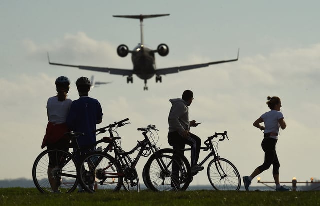 People gather in Gravelly Point as an aircraft prepares to land at Ronald Reagan Washington National Airport on in December 2015, in Arlington, VA.
