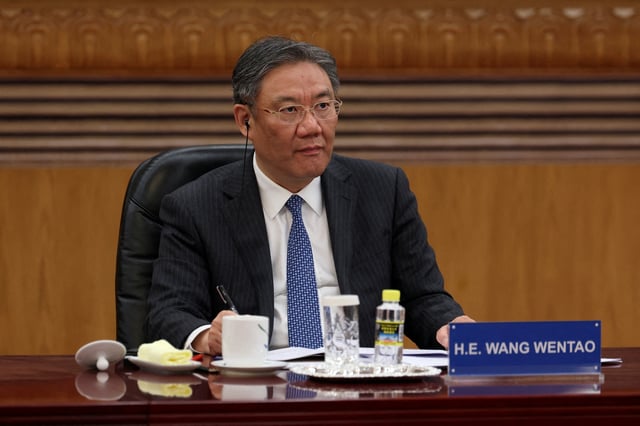 Chinese Commerce Minister Wang Wentao attends a meeting with global business leaders at the Great Hall of the People in Beijing, China, March 28, 2025. REUTERS/Florence Lo/File Photo