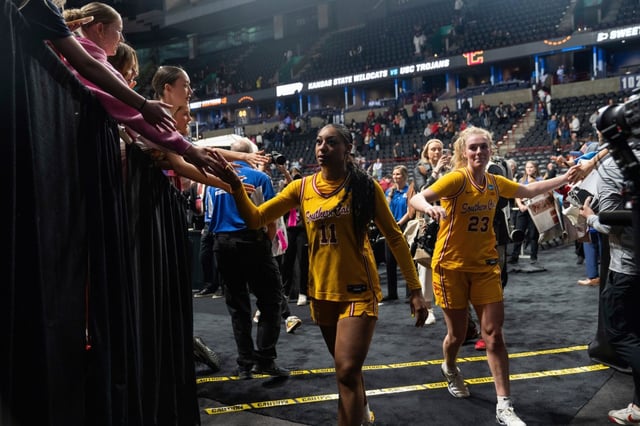 USC guard Kennedy Smith (11) and guard Avery Howell (23) greet fans as the leave the court after the Sweet 16 of the NCAA college basketball tournament against Kansas State, Saturday, March 29, 2025, in Spokane, Wash. (AP Photo/Jenny Kane)