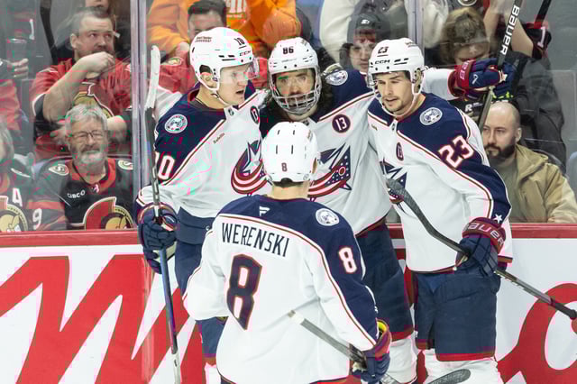 Mar 29, 2025; Ottawa, Ontario, CAN; Columbus Blue Jackets right wing Kirill Marchenko (86) celebrates with left wing Dimitri Voronkov (10) defenseman Zach Werenski (8) and center Sean Monahan (23) his goal scored in the third period against the Ottawa Senators at the Canadian Tire Centre. Mandatory Credit: Marc DesRosiers-Imagn Images