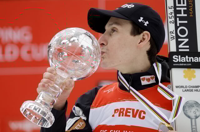 Ski Jumping - FIS Ski Jumping World Cup - Planica, Slovenia - March 30, 2025 Slovenia's Domen Prevc celebrates with a trophy on the podium after winning the small Crystal Globe for Ski Flying REUTERS/Borut Zivulovic