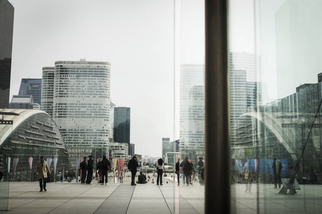 FILE - People stroll Friday, March 21, 2025 in La Defense business district outside Paris. (AP Photo/Thomas Padilla, file)