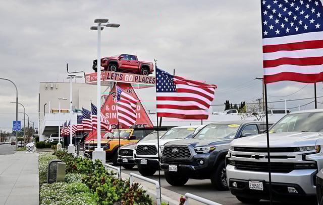 US flags fly outside a car dealership in Alhambra, California, on March 27, 2025, after President Donald Trump announced significant tariffs on imported vehicles and parts.