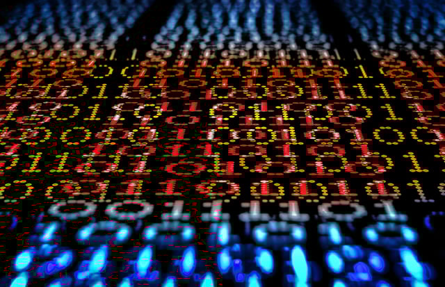 Binary code, ones and zeros in a 1970 dot matrix font on a computer screen. An infinity and lens bokeh effect applied.