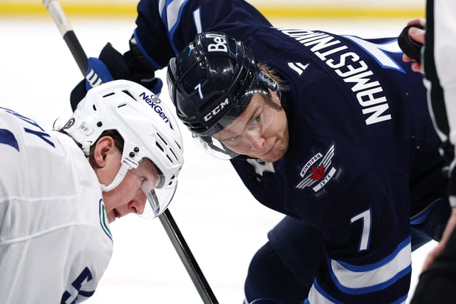 Mar 30, 2025; Winnipeg, Manitoba, CAN; Vancouver Canucks center Aatu Raty (54) and Winnipeg Jets center Vladislav Namestnikov (7) face off in the second period at Canada Life Centre. Mandatory Credit: James Carey Lauder-Imagn Images