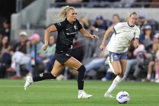 Angel City FC forward Riley Tiernan, left, brings the ball up th pitch chased by Seattle Reign FC forward Maddie Dahlien during the second half of an NWSL match at BMO Stadium in Los Angeles, on Sunday, March 30, 2025.  Angel City FC won 2-1.  (Photo by Raul Romero Jr., Contributing Photographer)