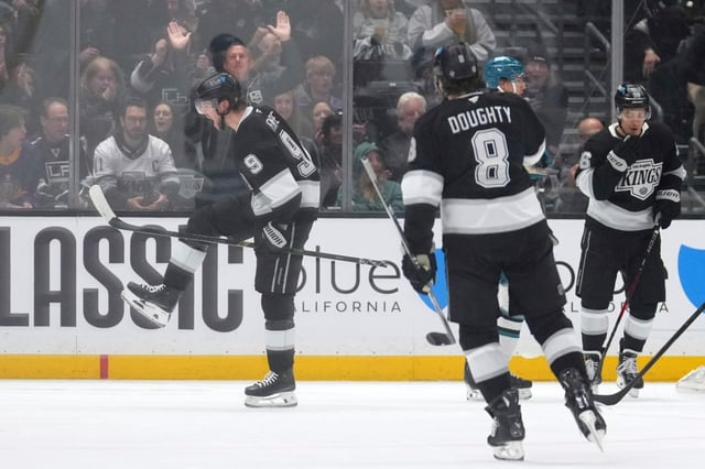 Kings right wing Adrian Kempe, left, celebrates after scoring while defenseman Drew Doughty, center, and defenseman Joel Edmundson react during the first period of an NHL hockey game against the San Jose Sharks, Sunday, March 30, 2025, in Los Angeles. (AP Photo/Mark J. Terrill)