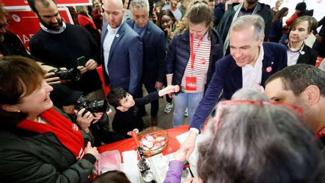 Canada's Prime Minister and Liberal Party leader Mark Carney greets volunteers and supporters during a stop at his campaign office in Ottawa, Ontario, on Saturday. (REUTERS)