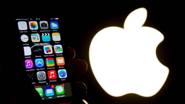 An illustration of an iPhone held up in front of the Apple Inc. logo taken of January 30, 2015 in Lille. Apple was fined �150 million on March 31, 2025 for abuse of a dominant position in the targeting of advertising on its devices, announced the French Competition Authority, while similar investigations are targeting the company in other European countries.