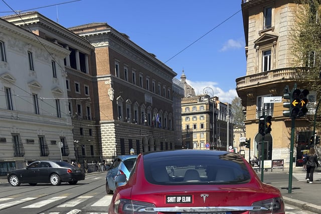 A Tesla vehicle has a sticker displayed on the rear trunk in Rome, Sunday, March 30, 2025. (AP Photo/Gregorio Borgia)
