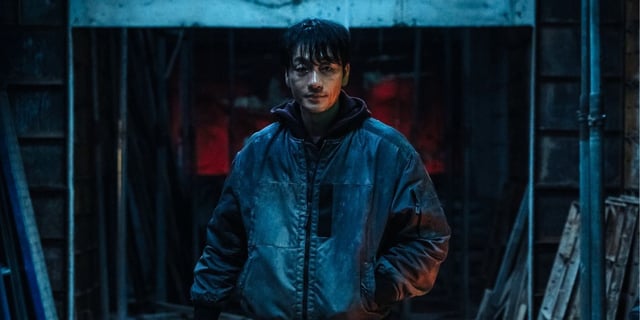 Park Hae-soo as The Witness standing in abandoned building in Netflix's Karma