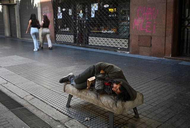A man sleeps on a bench near Argentina's presidential palace, Casa Rosada, in Buenos Aires, Argentina March 29, 2025. REUTERS/Mariana Nedelcu