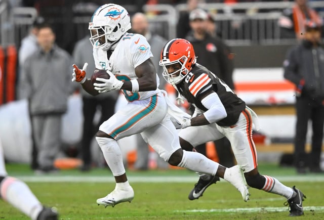 Miami Dolphins wide receiver Tyreek Hill, left, runs as Cleveland Browns cornerback Denzel Ward (21) defends during the first half of an NFL football game Sunday, Dec. 29, 2024, in Cleveland. (AP Photo/David Richard)