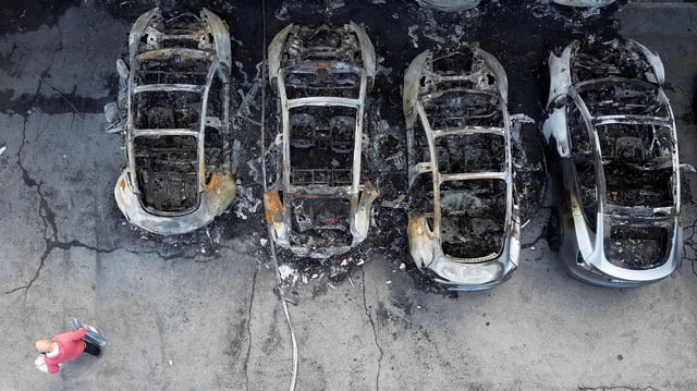 A drone view shows charred Tesla vehicles following a fire at a Tesla dealership that destroyed vehicles, in Rome, Italy, March 31, 2025.