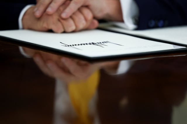 U.S. President Donald Trump places his hands on a signed executive order in the Oval Office of the White House in Washington, D.C., U.S., March 7, 2025. REUTERS/Evelyn Hockstein/File Photo