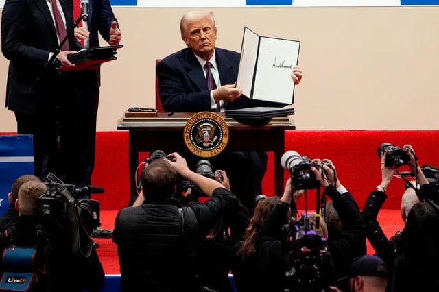 President Donald Trump signs executive orders Jan. 20 at Capital One Arena in Washington.
