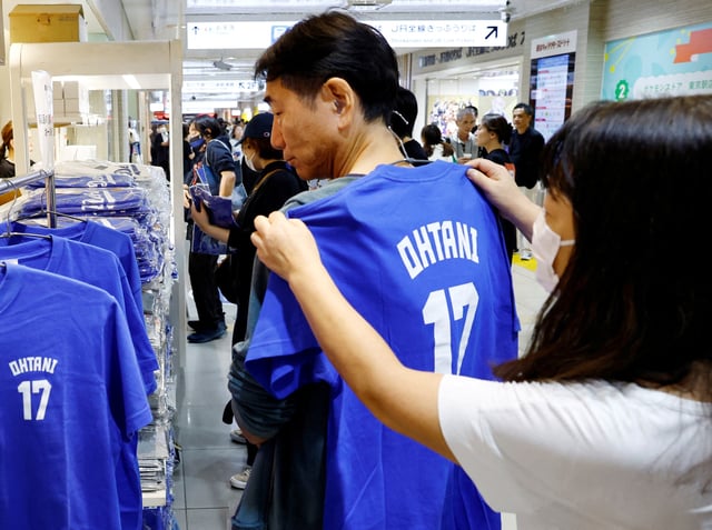 Customers choose a T-shirt at a pop-up store for Major League Baseball (MLB) star Shohei Ohtani ahead of the first World Series game between the Los Angeles Dodgers and the New York Yankees, in Tokyo, Japan October 25, 2024. REUTERS/Kim Kyung-Hoon/File Photo