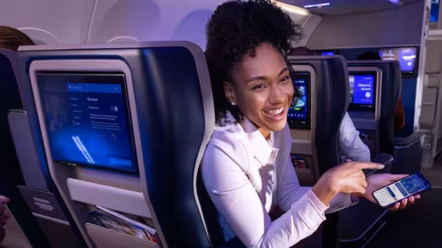 A lady enjoying fast Wi-Fi enabled by Starlink in an United Airlines flight.