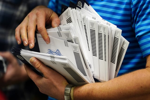 Kyle Hallman, with Chester County Voter Services, organizes mail-in ballots to be sorted for the 2020 General Election in the United States, Friday, Oct. 23, 2020, in West Chester, Pa.