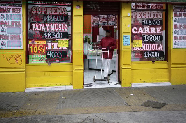 A worker pushes a dolly at a butcher in Buenos Aires, Argentina, Monday, March 31, 2025. (AP Photo/Natacha Pisarenko)