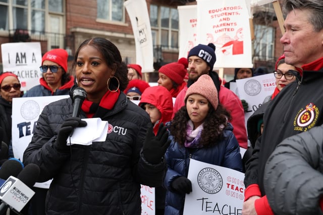 Chicago Teachers Union President Stacy Davis Gates, speaks as President Chicago Firefighters Local 2, Pat Cleary, right, listens while  dozens of Chicago Teachers Union and firefighter union members and supporters rally on March 24, 2025. (Antonio Perez/Chicago Tribune)