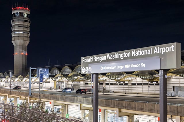 Ronald Reagan Washington National Airport sign inscription in front of the airport terminal. Exterior night view of Ronald Reagan Washington National Airport DCA in Crystal City, Virginia, United States serving Washington, D.C. The illuminated airport terminal building and the air traffic control tower of the airport visible at the departure level. The airport is owned by the federal government serving more than 25 million passengers, hub for American Airlines. Crystal City, Virginia, United States of America on November 9, 2024 (Photo by Nicolas Economou/NurPhoto via Getty Images)