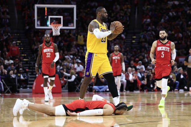 LeBron James #23 of the Los Angeles Lakers passes the bal ahead of Dillon Brooks #9 of the Houston Rockets during the second half at Toyota Center on January 29, 2024 in Houston, Texas.