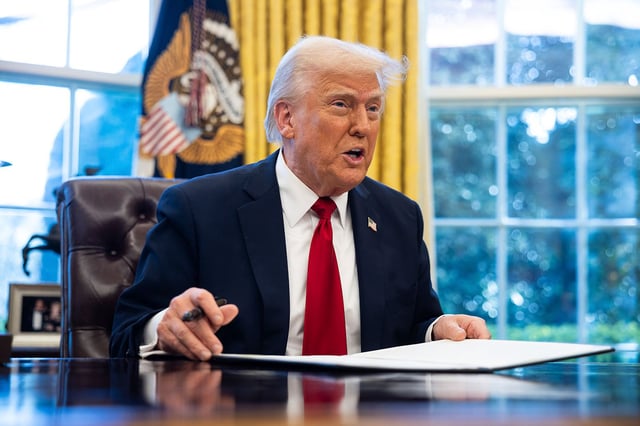 President Donald Trump signs an executive order on auto tariffs in the Oval Office at the White House March 26, 2025.