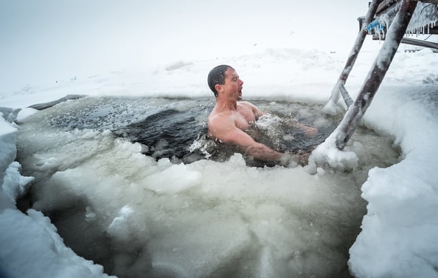 Stock image of a man taking a dip in an icy lake.