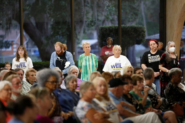People stand in the rear while listening to Josh Weil, a schoolteacher and Democratic candidate for Florida's 6th Congressional District seat in the U.S. House of Representatives,speaking at a town hall event at the Silver Springs Shores Community Center in Ocala, Florida, U.S. March 26, 2025.