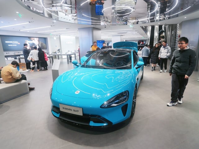 Customers experience a Xiaomi SU7 electric car at Xiaomi's flagship smart home store in Shanghai, China.
