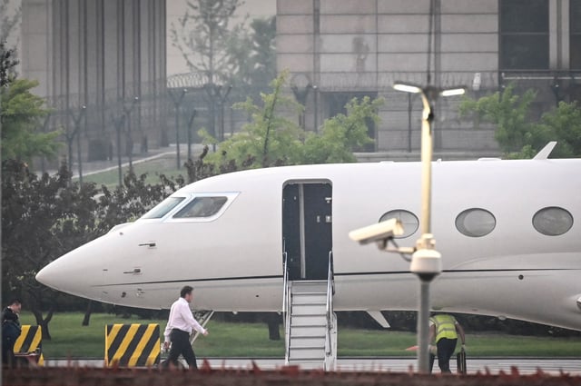 Tesla Chief Executive Officer Elon Musk (in white) boards his private jet.