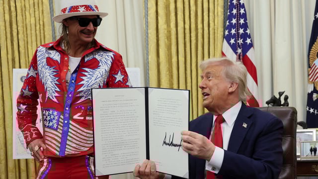 Donald Trump holds an executive order related to the U.S. live entertainment ticketing industry, next to Kid Rock, in the Oval Office at the White House in Washington, D.C., March 31, 2025. REUTERS/Leah Millis TPX IMAGES OF THE DAY
