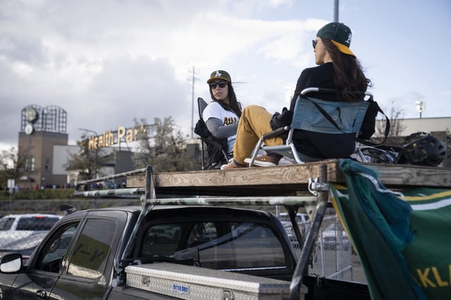 Kelsey McFadyen, left, and Krysta Kellegrew enjoy drinks on top of a truck before the Oakland Athletics’ home opener against the Chicago Cubs at parking lot of Sutter Health Park in Sacramento, Calif., Monday, March 31, 2025.