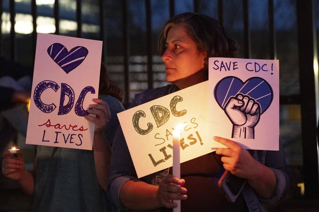 People gather for a candlelight vigil in support of the Centers for Disease Control and Prevention in front of its headquarters in Atlanta, Friday, March 28, 2025. (AP Photo/Ben Gray)