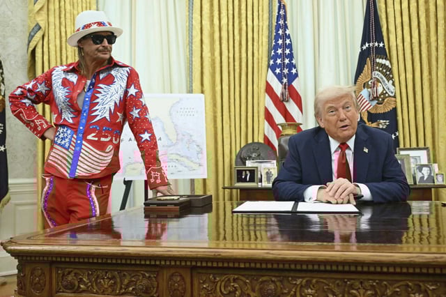 President Donald Trump speaks to reporters before signing an executive order in the Oval Office of the White House in Washington, Monday, March 31, as Kid Rock listens. 