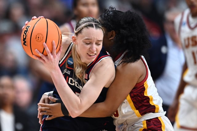 Mar 31, 2025; Spokane, WA, USA; UConn Huskies guard Paige Bueckers (5) is fouled by USC Trojans guard Malia Samuels (10) during the second half of an Elite 8 NCAA Tournament basketball game at Spokane Arena. Mandatory Credit: James Snook-Imagn Images