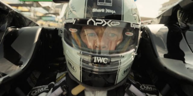 Brad Pitt wearing a racing helmet while driving in F1.