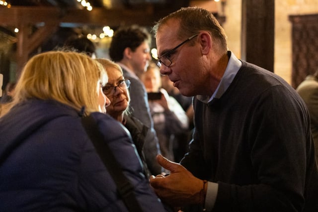 Aurora mayoral challenger John Leasch talks with supporters Dorothy Thompson, center, and Loretta Burke during his watch party at Two Brothers Roundhouse on April 1, 2025. (Audrey Richardson/Chicago Tribune)