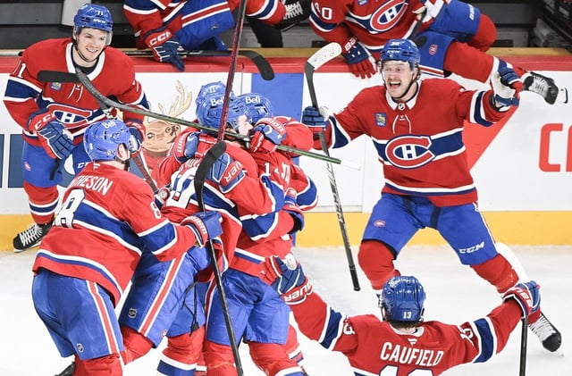 Montreal Canadiens' Nick Suzuki (14) celebrates with teammates after scoring the winning goal against the Florida Panthers during overtime NHL hockey action in Montreal, Tuesday, April 1, 2025. THE CANADIAN PRESS/Graham Hughes